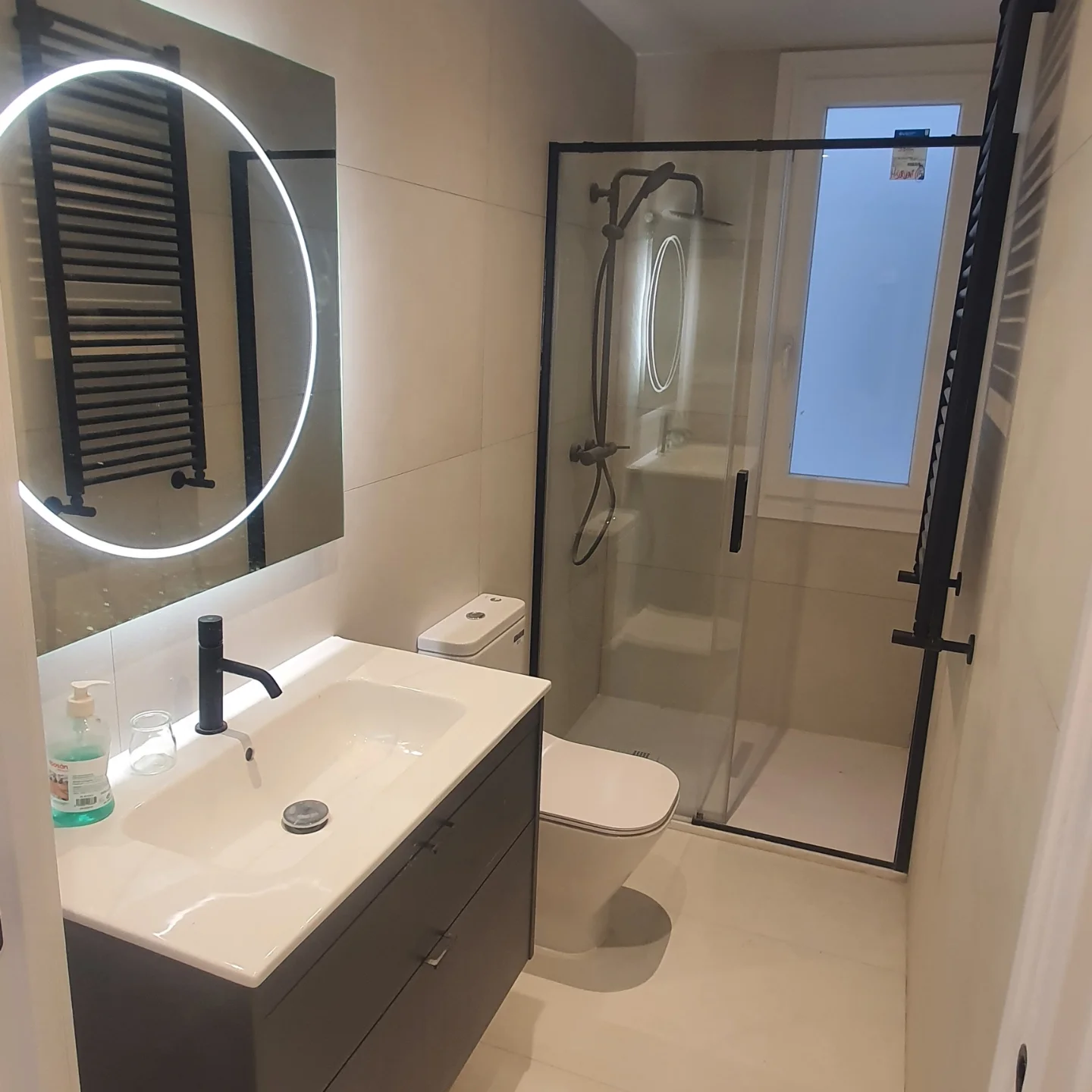 Reforma de baño con ducha de obra y espejo retroiluminado en Madrid
